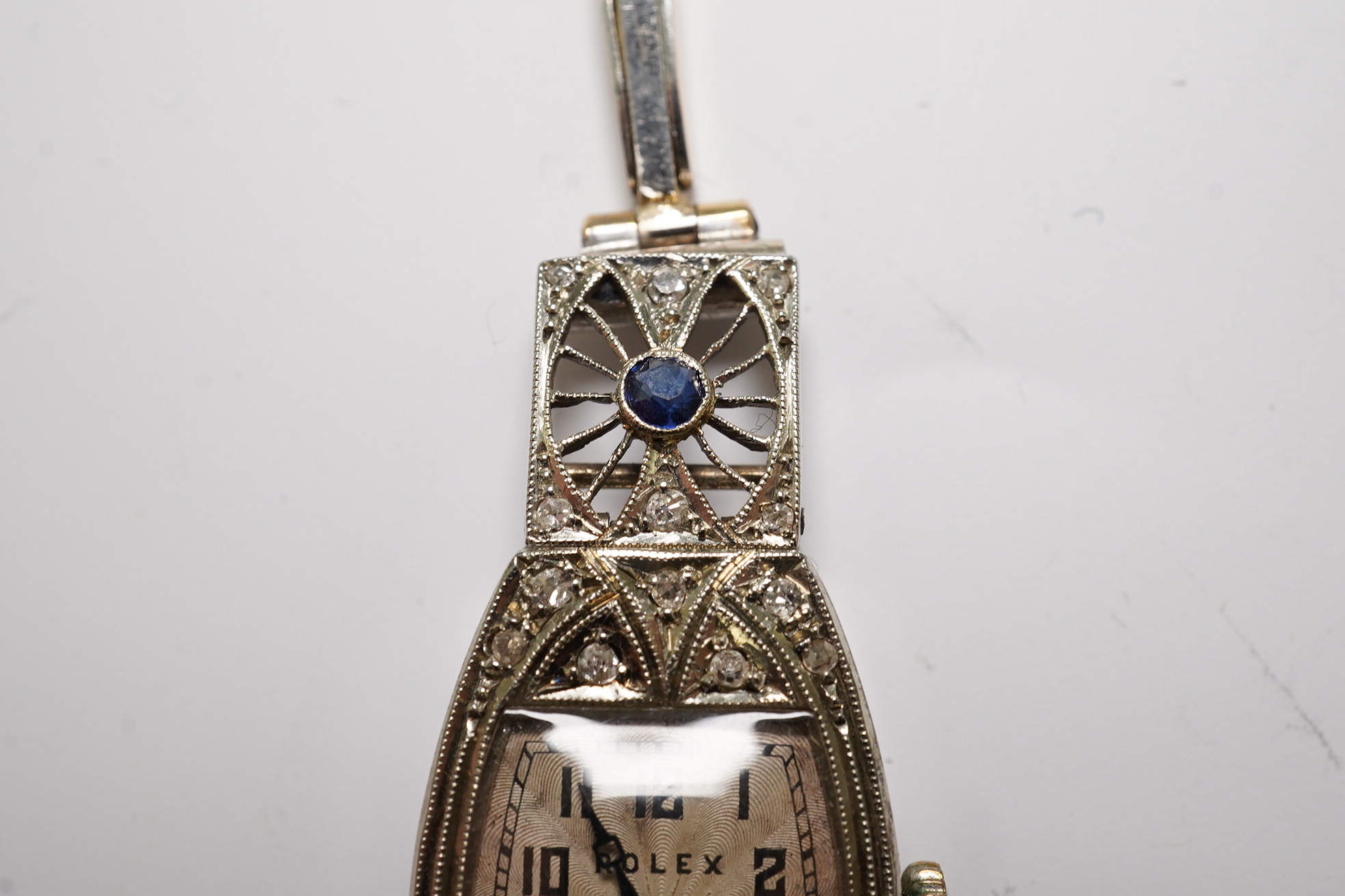 A lady's 1930's Art Deco pierced 18ct gold, sapphire and diamond set Rolex manual wind cocktail watch, on an 18ct gold and platinum expanding bracelet